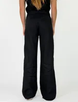 Pantalón marrón de lino de corte recto y holgado, con costuras decorativas claras a lo largo de las piernas.