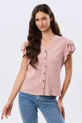 Camisa de lino y viscosa color beige, con cuello mao, escote en V y botones frontales de madera. Presenta mangas cortas con volados delicados.