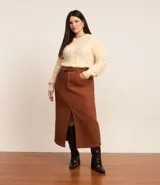 Suéter de punto pesado color crema, con cuello redondo y mangas largas. Presenta textura trenzada.