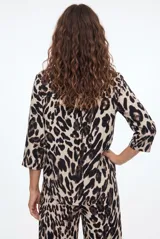 Camisa de manga larga con estampado animal print tipo leopardo, cuello camisero y cierre frontal de botones negros.