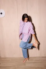 Camisa holgada de popelina de algodón a rayas verticales rosas, grises y azules. Presenta una abertura frontal con ribete festoneado en color azul marino y botones oscuros.