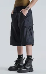 Pantalón cargo negro convertible, con cierre en la parte media de la pierna que permite transformarlo en un short ancho. Presenta bolsillos cargo a los lados y un corte holgado.
