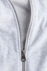 Campera corta de velour gris claro, de corte holgado, con cuello elevado, cierre frontal y bolsillos al bies. Presenta elástico fruncido en puños y bajo.