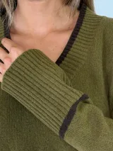 Sweater de punto color bordó con cuello en V, manga larga con puños acanalados y detalle de franja en contraste. Presenta un diseño holgado con aberturas laterales.