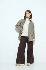 Canguro negro de silueta amplia con capucha integrada y detalles de líneas blancas que recorren el frente y las mangas.