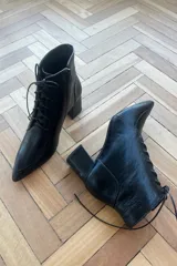 Botín de cuero vacuno color bronce metalizado, con diseño acordonado, cierre lateral interno y taco cuadrado.