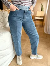 Jean mom fit de tiro alto color azul, con costuras frontales en contraste y pretina ancha con botones decorativos. Confeccionado en denim de algodón con elasticidad.