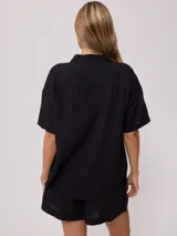 Camisa color verde lima, de manga corta, con bolsillo en el pecho y cierre con botones.