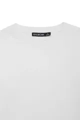 Remera básica blanca de manga larga con cuello redondo y corte regular. Confeccionada en tejido de punto liso.