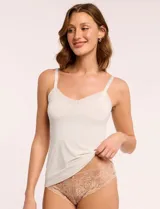 Musculosa íntima de microfibra color blanco, con escote en V y detalle de malla en los bordes. Cuenta con tirantes regulables y diseño antiestático.