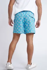 Short de baño con cintura elástica y cordón ajustable, confeccionado en tela ligera de secado rápido. Presenta un estampado botánico integral en tonos amarillos, blancos y azules, con dos bolsillos delanteros y uno posterior.