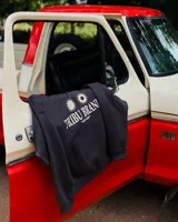 Canguro oversized color negro con estampado frontal en blanco que incluye dos soles y el texto "TRIBU BRAND".