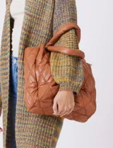 Cartera de eco cuero color marrón, con diseño capitoneado en rombos de gran relieve. Cuenta con un compartimento principal con cierre, amplios bolsillos laterales con botones imantados, asa de mano fija y correa larga regulable y removible. El forro interno es textil a tono con compartimentos organizadores.