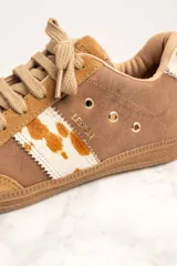 Zapatillas bajas color marrón con detalles en cuero con estampado de vaca en los laterales y talón.