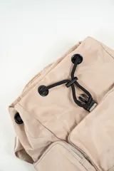 Mochila de nylon color lila con cierre de hebilla frontal, bolsillo exterior con cierre y bolsillos laterales con cierre.