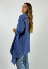 Camisola color beige con calados circulares, mangas 3/4 con trabilla y cuello con solapa.