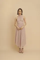 Vestido midi de fiesta confeccionado en microtul, color rosado, con diseño sin mangas, cuello halter fruncido y falda con vuelo de largo midi.