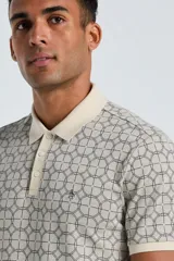 Polo de manga corta con estampado geométrico de círculos entrelazados. Presenta cuello y puños en color crema en contraste, cierre frontal con tres botones y logo bordado en el pecho.