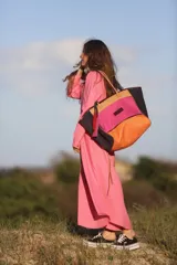 Bolso de fin de semana estilo tote de lona con estampado camuflado, detalles en cuero marrón y gamuza azul, manijas largas y borla decorativa colgante.