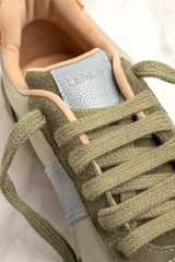 Zapatillas deportivas bajas de cuero color verde con detalles en verde oliva y celeste.