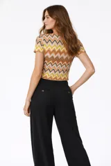 Top de punto con estampado de zigzag multicolor, cuello en V y cierre frontal con lazo anudado. Presenta mangas cortas y un ajuste al cuerpo.