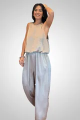 Mono largo de tela satinada color beige, con diseño sin mangas, cuello redondo con detalle de aplique brillante y cintura elástica con caída fluida.