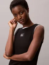 Musculosa Calvin Klein de corte slim confeccionada en tejido de canalé de algodón con elastano. Presenta cuello redondo, tirantes anchos y una etiqueta con el monograma CK en el centro del pecho.