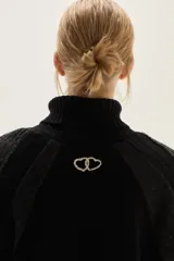 Polera de cuello alto confeccionada en lana lambswool, con diseño de bloques de color en tonos beige y marrón. Presenta mangas raglán con textura acanalada y detalles en hilo metalizado lurex.