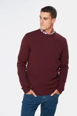 Buzo tejido de lana con escote redondo a la base, de manga larga y calce clásico.