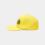 Gorra amarilla con visera curva, confeccionada en algodón. Cuenta con bordado frontal con el texto "EMEST ALWAYS" y un escudo distintivo en negro.