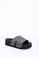 Sandalia de plataforma plana color negro, con faja de gamuza con estampado animal print en tonos grises y negros, decorada con tachas metálicas plateadas.