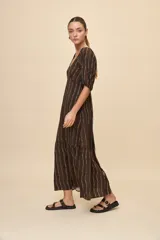 Vestido largo celeste con estampado botánico en tonos marrones, escote en V, mangas cortas abullonadas y falda con volado en el bajo.