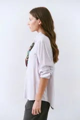 Camisa blanca de manga larga con cuello clásico, cierre de botones frontal y bolsillo de parche en el pecho.