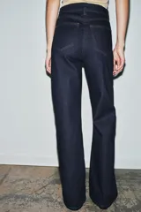 Jeans de tiro alto estilo wide leg, color marrón oscuro, con diseño de cinco bolsillos y cierre frontal de cremallera y botón metálico.