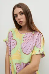 Vestido corto con estampado floral en tonos amarillo, verde y lila.