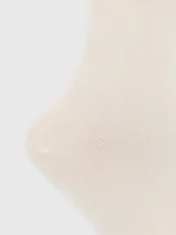Calcetín de largo medio en color beige, confeccionado en tejido suave con puño elástico y logo bordado del perro de la marca en la parte superior.