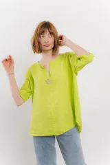 Blusa holgada de lino color verde brillante, con cuello mao abierto y manga corta enrollada. Presenta bordados estilo paisley en tono a tono y un botón de madera en el escote.