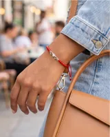 Pulsera de hilo rojo ajustable con tres dijes de corazones en plata 925 y terminaciones con esferas de plata.