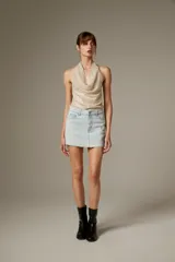 Top de poliéster revestido de lentejuelas color beige, con cuello buche y diseño sin mangas al cuerpo.