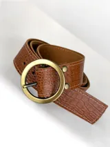 Cinturón de cuero con textura de reptil en color marrón, con hebilla circular metálica en tono dorado envejecido.
