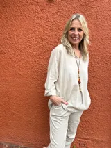 Camisa Milena de color beige, de manga larga con puños arremangados y cuello abierto con escote en V.