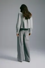 Jean de corte wide leg y tiro medio en denim color gris deslavado, con diseño de cinco bolsillos y cierre frontal con botón y cremallera.