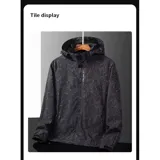 Campera cortaviento impermeable de la marca Uniteduy, color negro con estampado sutil de hojas. Cuenta con capucha, cierre frontal, tres bolsillos externos y uno interno. Es una prenda ultra liviana y transpirable, ideal para actividades al aire libre.