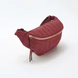 Riñonera color borgoña con diseño acolchado, cierre dorado y correa ajustable.