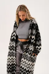 Tapado largo de lana con estampado zigzag horizontal en tonos grises y negros, de manga larga y abotonado.