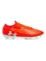 Championes de fútbol Under Armour Magnetico Select 4 FG, color naranja vibrante con detalles en gris claro y verde lima. Presentan una parte superior de piel sintética con estampado 3D para mayor control, cuello textil tipo calcetín y suela de TPU con tacos cónicos.