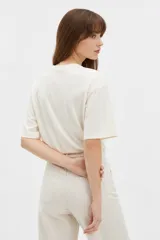 Remera de algodón negra con cuello redondo y mangas cortas, de corte holgado. Presenta estampado frontal en tonos de verde con la inscripción 'New York City Brooklyn' y el logo 'NY' rodeado de laureles.