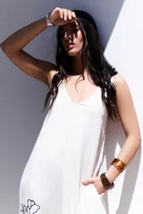 Vestido largo de corte holgado en color azul, con escote en V, breteles regulables y bolsillos laterales. Presenta un delicado diseño de flores bordadas en el lateral inferior.