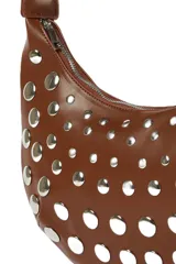 Cartera tipo baguette color marrón, con diseño de media luna y adornos de tachas plateadas de diferentes tamaños. Tiene una correa ajustable y cierre de cremallera.