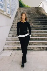 Camiseta de manga larga color gris melange, con cuello redondo y bajo recto. Presenta un detalle de tejido efecto doble a contraste en el cuello, puños y dobladillo inferior en color blanco.